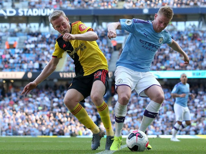 MANCHESTER, ENGLAND - SEPTEMBER 21:  Kevin De Bruyne of Manchester City battles with Will Hughes of Watford  during the Premier League match between Manchester City and Watford FC at Etihad Stadium on September 21, 2019 in Manchester, United Kingdom. (Photo by Jan Kruger/Getty Images)