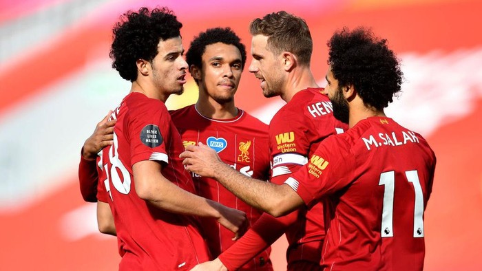 LIVERPOOL, ENGLAND - JULY 05: Curtis Jones of Liverpool celebrates with teammates after scoring his teams second goal during the Premier League match between Liverpool FC and Aston Villa at Anfield on July 05, 2020 in Liverpool, England.Football Stadiums around Europe remain empty due to the Coronavirus Pandemic as Government social distancing laws prohibit fans inside venues resulting in games being played behind closed doors. (Photo by Paul Ellis/Pool via Getty Images)