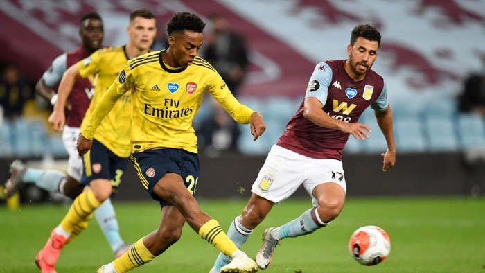 BIRMINGHAM, ENGLAND - JULY 21: Joe Willock of Arsenal shoots past Trezeguet of Aston Villa  during the Premier League match between Aston Villa and Arsenal FC at Villa Park on July 21, 2020 in Birmingham, England. Football Stadiums around Europe remain empty due to the Coronavirus Pandemic as Government social distancing laws prohibit fans inside venues resulting in all fixtures being played behind closed doors. (Photo by Peter Powell/Pool via Getty Images)