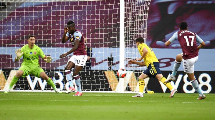 Aston Villas Trezeguet, right, scores his teams first goal during the English Premier League soccer match between Aston Villa and Arsenal at Villa Park in Birmingham, England, Tuesday, July 21, 2020. (AP Photo/Peter Powell,Pool)