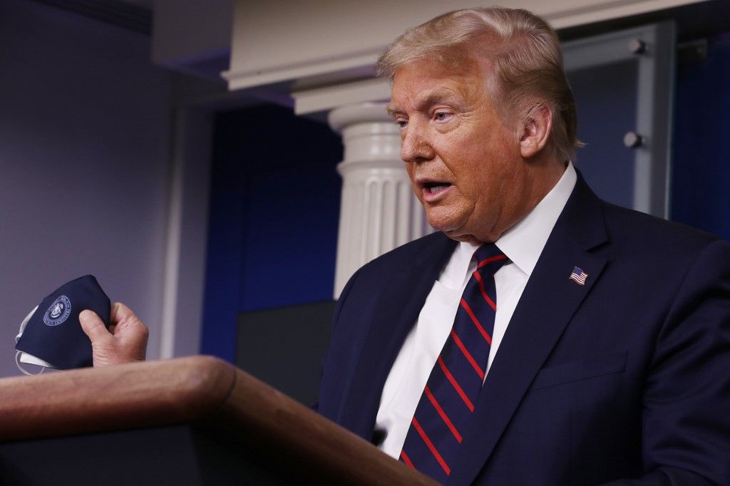 WASHINGTON, DC - JULY 21: U.S. President Donald Trump talks to holds up his face mask during a press conference in the Brady Press Briefing Room at the White House July 21, 2020 in Washington, DC. Trump focused on his administration's handling of the global coronavirus pandemic. Poll numbers about his handling of COVID-19 have been falling as cases of deadly virus have spiked across the country.   Chip Somodevilla/Getty Images/AFP
