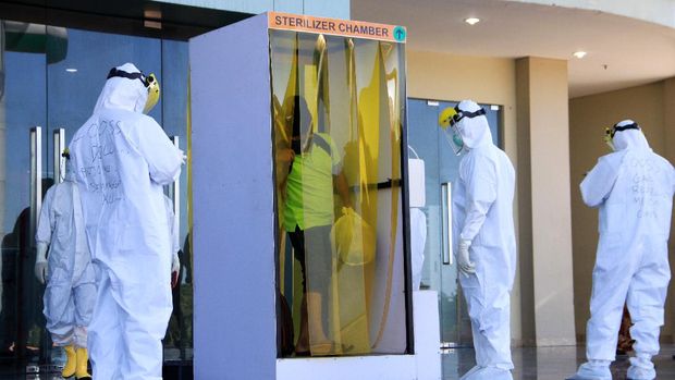 Seorang Tanpa Gejala (OTG) yang telah sembuh dari COVID-19 keluar dari bilik disinfektan saat acara pelepasan di gedung Mal Pelayanan Publik kawasan lingkar timur Sidoarjo, Jawa Timur, Selasa (7/7/2020). Pasmar 2 bekerja sama dengan Pemkab Sidoarjo melepas 13 pasien Orang Tanpa Gejala yang sudah menjalani perawatan di ruang isolasi  dan dinyatakan sembuh. ANTARA FOTO/Umarul Faruq/foc.