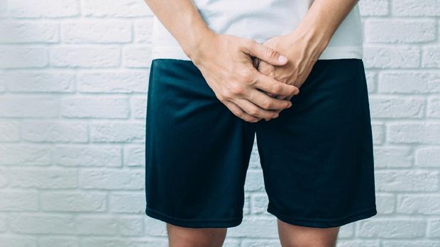 man wearing shorts holding genitals. Men's health, venereologist, sexual disease