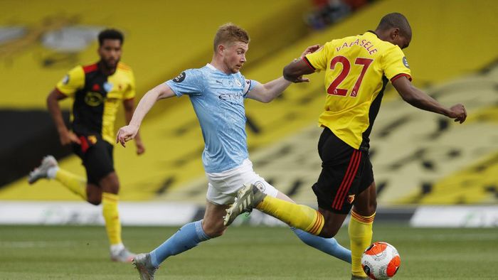 WATFORD, ENGLAND - JULY 21: Kevin De Bruyne of Manchester City  battles for possession with  Christian Kabasele of Watford  during the Premier League match between Watford FC and Manchester City at Vicarage Road on July 21, 2020 in Watford, England. Football Stadiums around Europe remain empty due to the Coronavirus Pandemic as Government social distancing laws prohibit fans inside venues resulting in all fixtures being played behind closed doors. (Photo by Adrian Dennis/Pool via Getty Images)