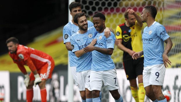 Manchester City's Raheem Sterling, centre, celebrates with teammates after scoring his side's second goal during the English Premier League soccer match between Watford and Manchester City at the Vicarage Road Stadium in Watford, England, Tuesday, July 21, 2020. (Adrian Dennis/Pool via AP)