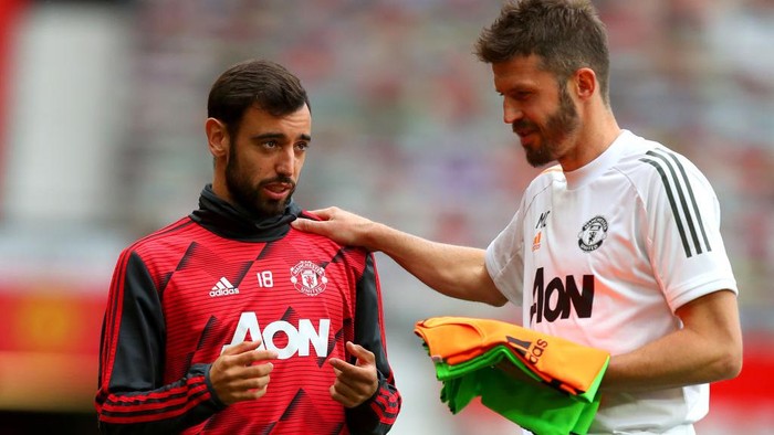 Bruno Fernandes MANCHESTER, ENGLAND - JULY 22: Bruno Fernandes of Manchester United and Michael Carrick, Manchester United Assistant Coach speak prior to the Premier League match between Manchester United and West Ham United at Old Trafford on July 22, 2020 in Manchester, England. Football Stadiums around Europe remain empty due to the Coronavirus Pandemic as Government social distancing laws prohibit fans inside venues resulting in all fixtures being played behind closed doors. (Photo by Catherine Ivill/Getty Images)