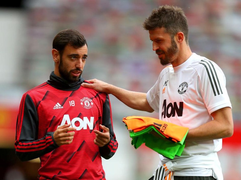 MANCHESTER, ENGLAND - JULY 22: Bruno Fernandes of Manchester United and Michael Carrick, Manchester United Assistant Coach speak prior to the Premier League match between Manchester United and West Ham United at Old Trafford on July 22, 2020 in Manchester, England. Football Stadiums around Europe remain empty due to the Coronavirus Pandemic as Government social distancing laws prohibit fans inside venues resulting in all fixtures being played behind closed doors. (Photo by Catherine Ivill/Getty Images)