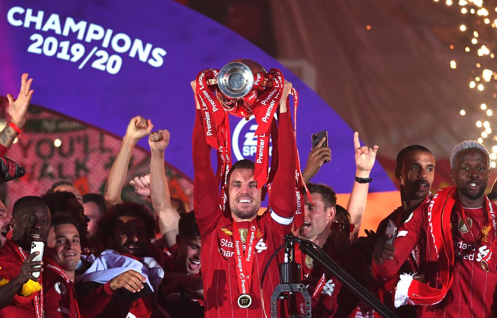 LIVERPOOL, ENGLAND - JULY 22: Jordan Henderson of Liverpool lifts The Premier League trophy following the Premier League match between Liverpool FC and Chelsea FC at Anfield on July 22, 2020 in Liverpool, England. Football Stadiums around Europe remain empty due to the Coronavirus Pandemic as Government social distancing laws prohibit fans inside venues resulting in all fixtures being played behind closed doors. (Photo by Laurence Griffiths/Getty Images)