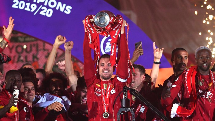LIVERPOOL, ENGLAND - JULY 22: Jordan Henderson of Liverpool lifts The Premier League trophy following the Premier League match between Liverpool FC and Chelsea FC at Anfield on July 22, 2020 in Liverpool, England. Football Stadiums around Europe remain empty due to the Coronavirus Pandemic as Government social distancing laws prohibit fans inside venues resulting in all fixtures being played behind closed doors. (Photo by Laurence Griffiths/Getty Images)