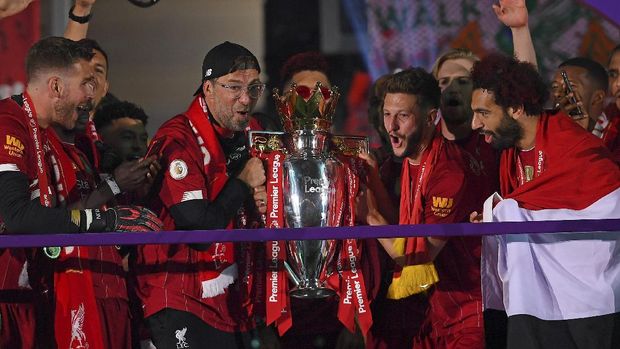 Liverpool's manager Jurgen Klopp and Liverpool's Adam Lallana hold the English Premier League trophy following the English Premier League soccer match between Liverpool and Chelsea at Anfield Stadium in Liverpool, England, Wednesday, July 22, 2020. Liverpool are champions of the EPL for the season 2019-2020. The trophy is presented at the teams last home game of the season. Liverpool won the match against Chelsea 5-3. (Laurence Griffiths, Pool via AP)