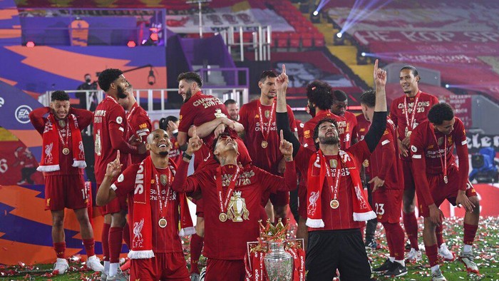 Liverpools Fabinho, left, Liverpools goalkeeper Alisson, right, and Roberto Firmino, all from Brazil, celebrate with the English Premier League trophy following the English Premier League soccer match between Liverpool and Chelsea at Anfield Stadium in Liverpool, England, Wednesday, July 22, 2020. Liverpool are champions of the EPL for the season 2019-2020. The trophy is presented at the teams last home game of the season. Liverpool won the match against Chelsea 5-3. (Laurence Griffiths, Pool via AP)