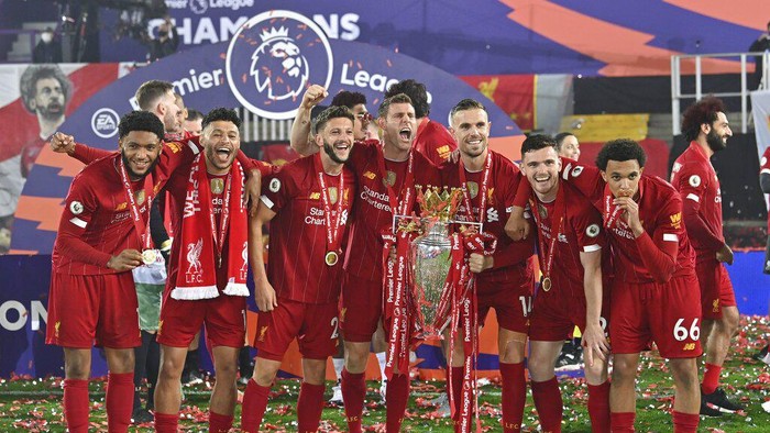 Liverpool players celebrate with the English Premier League trophy after it was presented following the Premier League soccer match between Liverpool and Chelsea at Anfield stadium in Liverpool, England, Wednesday, July 22, 2020. (Paul Ellis, Pool via AP)