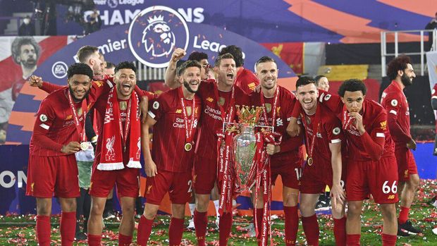 Liverpool players celebrate with the English Premier League trophy after it was presented following the Premier League soccer match between Liverpool and Chelsea at Anfield stadium in Liverpool, England, Wednesday, July 22, 2020. (Paul Ellis, Pool via AP)