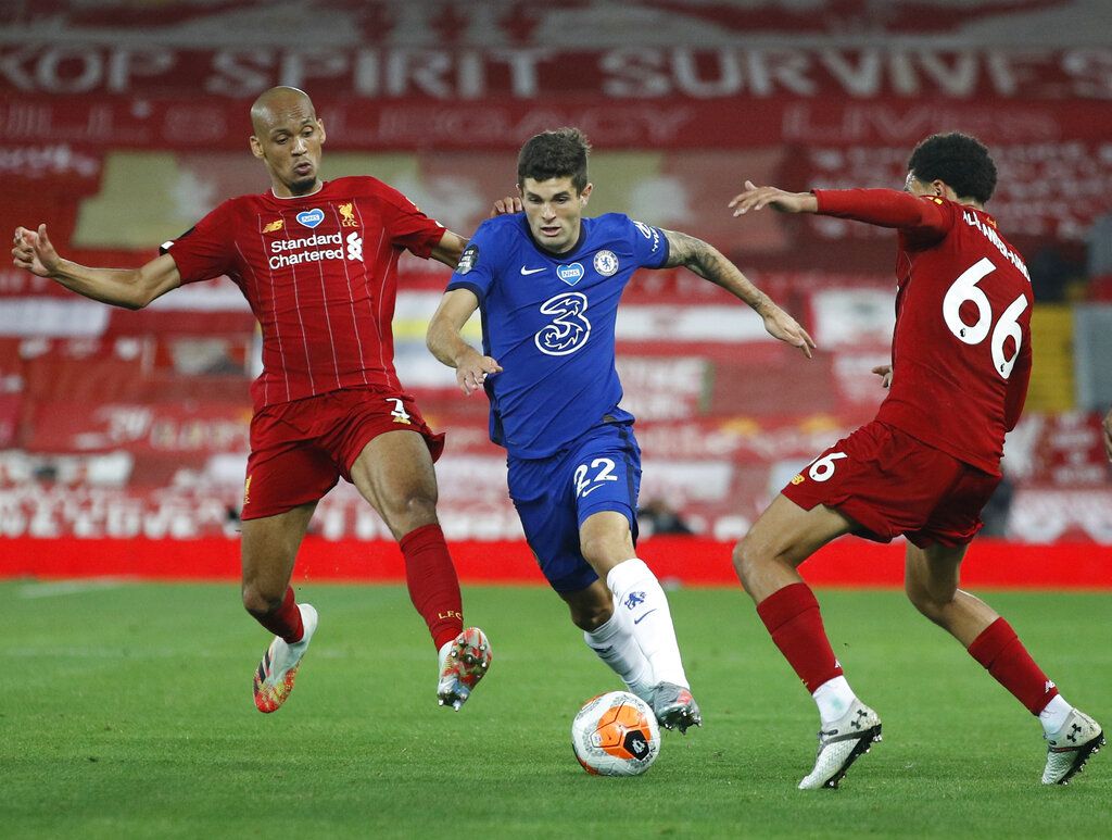 Chelsea's Christian Pulisic, center, vies for the ball with Liverpool's Fabinho, left and Liverpool's Trent Alexander-Arnold during the English Premier League soccer match between Liverpool and Chelsea at Anfield Stadium in Liverpool, England, Wednesday, July 22, 2020. (Phil Noble/Pool via AP)