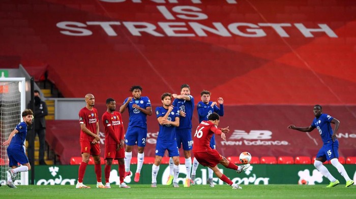 LIVERPOOL, ENGLAND - JULY 22: Trent Alexander-Arnold of Liverpool scores his teams second goal from a free kick during the Premier League match between Liverpool FC and Chelsea FC at Anfield on July 22, 2020 in Liverpool, England. Football Stadiums around Europe remain empty due to the Coronavirus Pandemic as Government social distancing laws prohibit fans inside venues resulting in all fixtures being played behind closed doors. (Photo by Laurence Griffiths/Getty Images)