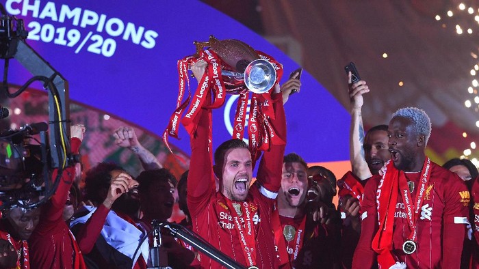 LIVERPOOL, ENGLAND - JULY 22: Jordan Henderson of Liverpool lifts The Premier League trophy following the Premier League match between Liverpool FC and Chelsea FC at Anfield on July 22, 2020 in Liverpool, England. Football Stadiums around Europe remain empty due to the Coronavirus Pandemic as Government social distancing laws prohibit fans inside venues resulting in all fixtures being played behind closed doors. (Photo by Laurence Griffiths/Getty Images)