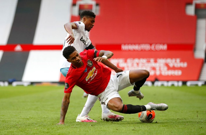 MANCHESTER, ENGLAND - JULY 22: Ben Johnson of West Ham United and Marcus Rashford of Manchester United clash during the Premier League match between Manchester United and West Ham United at Old Trafford on July 22, 2020 in Manchester, England. Football Stadiums around Europe remain empty due to the Coronavirus Pandemic as Government social distancing laws prohibit fans inside venues resulting in all fixtures being played behind closed doors. (Photo by Clive Brunskill/Getty Images)