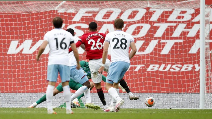MANCHESTER, ENGLAND - JULY 22: Mason Greenwood of Manchester United scores his teams first goal during the Premier League match between Manchester United and West Ham United at Old Trafford on July 22, 2020 in Manchester, England. Football Stadiums around Europe remain empty due to the Coronavirus Pandemic as Government social distancing laws prohibit fans inside venues resulting in all fixtures being played behind closed doors. (Photo by Clive Brunskill/Getty Images)