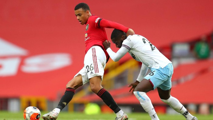 MANCHESTER, ENGLAND - JULY 22: Mason Greenwood of Manchester United and Arthur Masuaku of West Ham United battle for the ball during the Premier League match between Manchester United and West Ham United at Old Trafford on July 22, 2020 in Manchester, England. Football Stadiums around Europe remain empty due to the Coronavirus Pandemic as Government social distancing laws prohibit fans inside venues resulting in all fixtures being played behind closed doors. (Photo by Catherine Ivill/Getty Images)