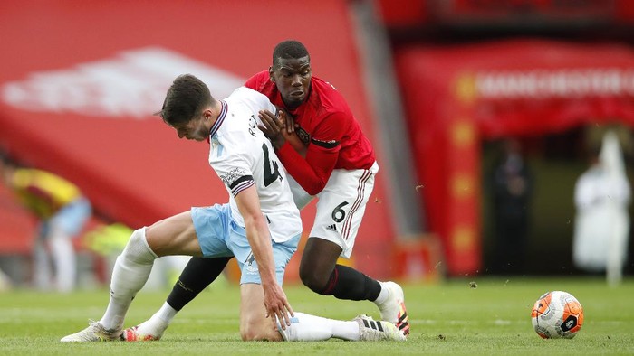 MANCHESTER, ENGLAND - JULY 22: Paul Pogba of Manchester United and Declan Rice of West Ham United battle for the ball during the Premier League match between Manchester United and West Ham United at Old Trafford on July 22, 2020 in Manchester, England. Football Stadiums around Europe remain empty due to the Coronavirus Pandemic as Government social distancing laws prohibit fans inside venues resulting in all fixtures being played behind closed doors. (Photo by Clive Brunskill/Getty Images)