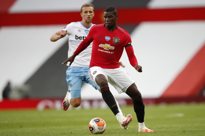 Manchester Uniteds Paul Pogba, center, fights for the ball with West Hams Tomas Soucek during the English Premier League soccer match between Manchester United and West Ham at the Old Trafford stadium in Manchester, England, Wednesday, July 22, 2020. (Clive Brunskill/Pool via AP)