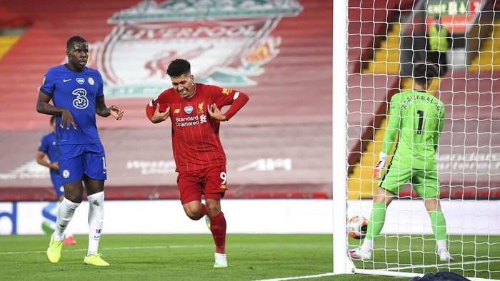 Liverpools Roberto Firmino, center, celebrates scoring his sides fourth goal during the English Premier League soccer match between Liverpool and Chelsea at Anfield stadium in Liverpool, England, Wednesday, July 22, 2020. (Laurence Griffiths, Pool via AP)