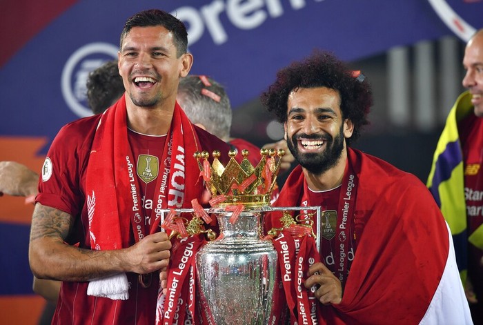 Liverpools Dejan Lovren and Liverpools Mohamed Salah celebrate with the English Premier League trophy aloft after it was presented following the Premier League soccer match between Liverpool and Chelsea at Anfield stadium in Liverpool, England, Wednesday, July 22, 2020. (Paul Ellis, Pool via AP)