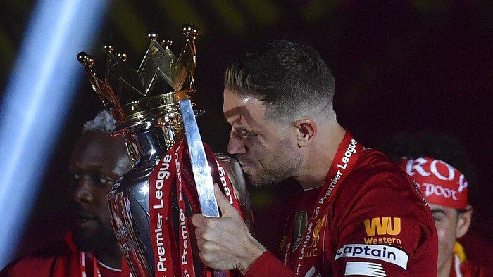 Liverpools Jordan Henderson kisses the English Premier League trophy after it was presented following the Premier League soccer match between Liverpool and Chelsea at Anfield stadium in Liverpool, England, Wednesday, July 22, 2020. (Paul Ellis, Pool via AP)