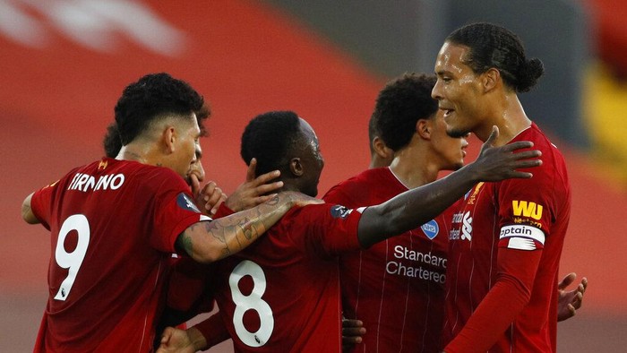 Liverpools Naby Keita, no 8, turns away to celebrate after scoring the opening goal of the game with teammates including Liverpools Virgil van Dijk, right, during the English Premier League soccer match between Liverpool and Chelsea at Anfield Stadium in Liverpool, England, Wednesday, July 22, 2020. (Phil Noble/Pool via AP)