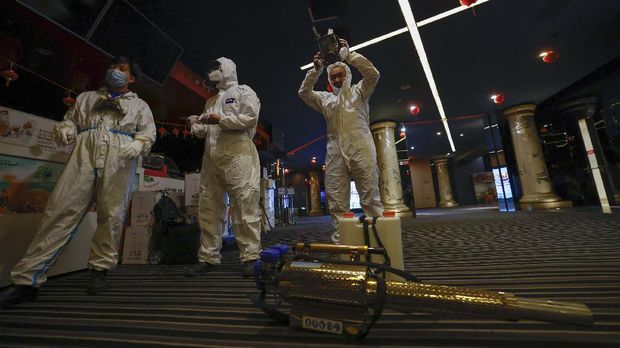 Volunteers with the Blue Sky Rescue team prepare to disinfect of a cineplex before it reopens for business in Beijing Friday, July 24, 2020. Theaters in China, the world's second largest movie market, this week reopened from the coronavirus shut down with theaters limited to 30% capacity. (AP Photo/Ng Han Guan)