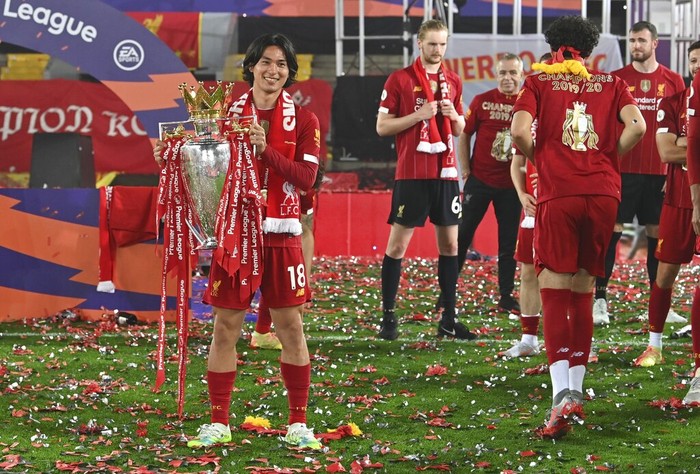 Takumi Minamino Liverpool's Takumi Minamino holds the English Premier League trophy aloft after it was presented following the Premier League soccer match between Liverpool and Chelsea at Anfield stadium in Liverpool, England, Wednesday, July 22, 2020. (Paul Ellis, Pool via AP)