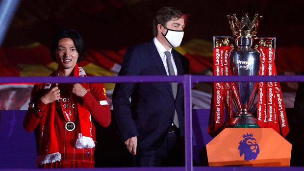 LIVERPOOL, ENGLAND - JULY 22: Takumi Minamino of Liverpool receives a Premier League Winner's medal following the Premier League match between Liverpool FC and Chelsea FC at Anfield on July 22, 2020 in Liverpool, England. Football Stadiums around Europe remain empty due to the Coronavirus Pandemic as Government social distancing laws prohibit fans inside venues resulting in all fixtures being played behind closed doors. (Photo by Phil Noble/Pool via Getty Images)