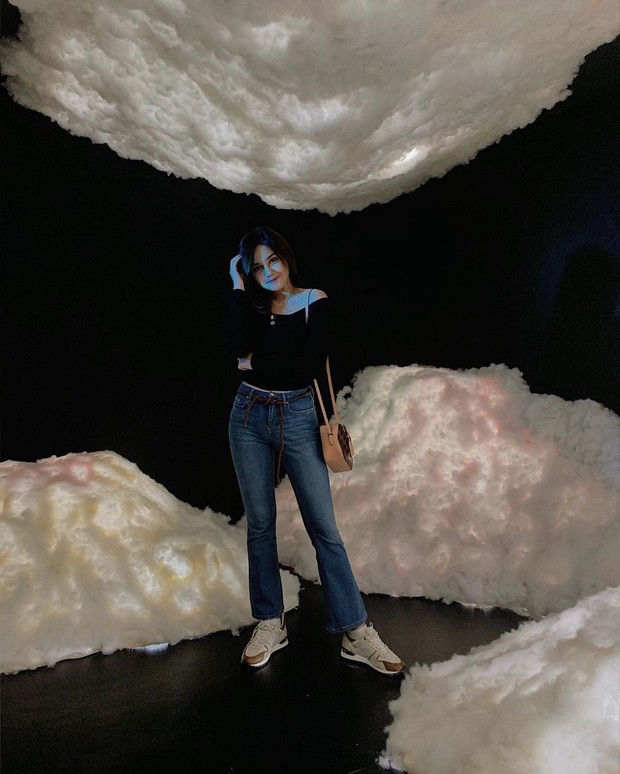 Syifa Hadju/instagram.com/syifahadjureal celana jeans dengan mode agak mengembang di bagian bawah serta menambahkan aksesori belt pada celananya.