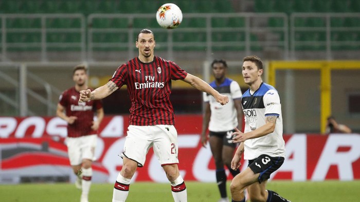 AC Milans Zlatan Ibrahimovic, vie for the ball with Atalantas Mattia Caldara, right, during the Serie A soccer match between AC Milan and Atalanta at the San Siro stadium, in Milan, Italy, Friday, July 24, 2020. (AP Photo/Antonio Calanni)