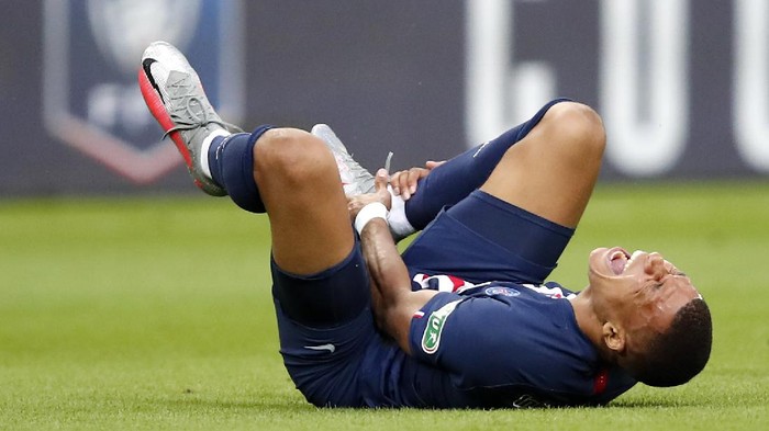 PSGs Kylian Mbappe shouts in pain after being tackled during the French Cup soccer final match between Paris Saint Germain and Saint Etienne at Stade de France stadium, in Saint Denis, north of Paris, Friday July 24, 2020. (AP Photo/Francois Mori)