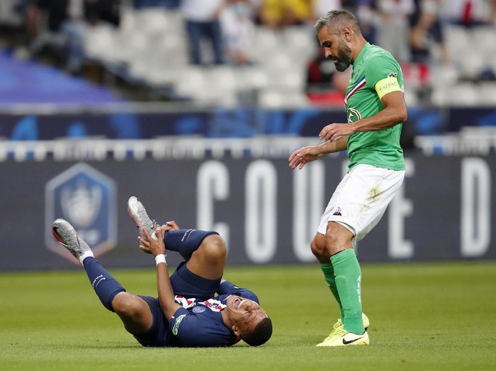 PSGs Kylian Mbappe, left, shouts in pain after being tackled by Saint-Etiennes Loic Perrin, right, during the French Cup soccer final match between Paris Saint Germain and Saint Etienne at Stade de France stadium, in Saint Denis, north of Paris, Friday July 24, 2020. (AP Photo/Francois Mori)