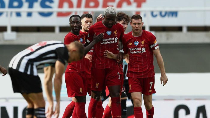 NEWCASTLE UPON TYNE, ENGLAND - JULY 26: Divock Origi of Liverpool celebrates with teammates after scoring his teams second goal  during the Premier League match between Newcastle United and Liverpool FC at St. James Park on July 26, 2020 in Newcastle upon Tyne, England. Football Stadiums around Europe remain empty due to the Coronavirus Pandemic as Government social distancing laws prohibit fans inside venues resulting in all fixtures being played behind closed doors. (Photo by Jan Kruger/Getty Images )