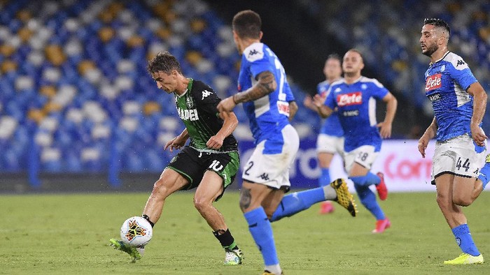 Sassuolos Filip Djuricic, left, vies for the ball during the Italian Serie A soccer match between Napoli and Sassuolo, at the San Paolo stadium in Naples, Italy, Saturday, July 25, 2020. (Cafaro/LaPresse via AP)