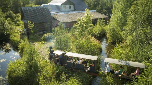 A miniature steam train runs across a bridge on Pavel Chilin's miniature personal narrow-gauge railway twisting through the grounds of his home in Ulyanovka village outside St. Petersburg, Russia Sunday, July 19, 2020. It took Chilin more than 10 years to build a 350-meter-long mini-railway twisting through the grounds of his cottage home about 50 kilometers (some 30 miles) outside St. Petersburg, complete with various branches, dead ends, circuit loops, and even three bridges.(AP Photo/Dmitri Lovetsky)