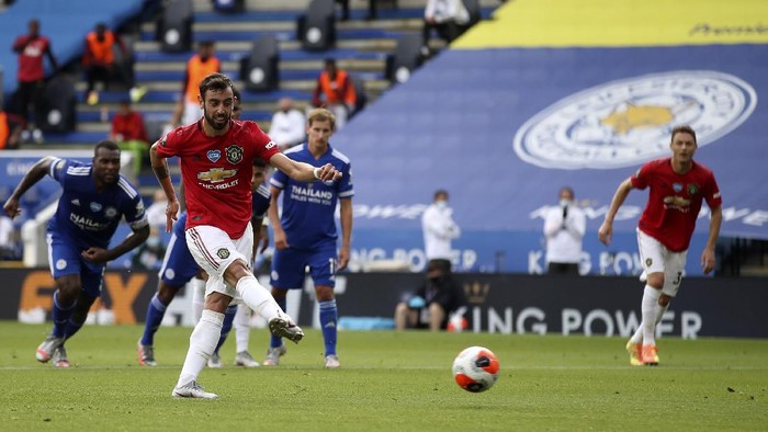 Manchester Uniteds Bruno Fernandes, front, scores his sides opening goal from the penalty spot during the English Premier League soccer match between Leicester City and Manchester United at the King Power Stadium, in Leicester, England, Sunday, July 26, 2020. (Carl Recine/Pool via AP)