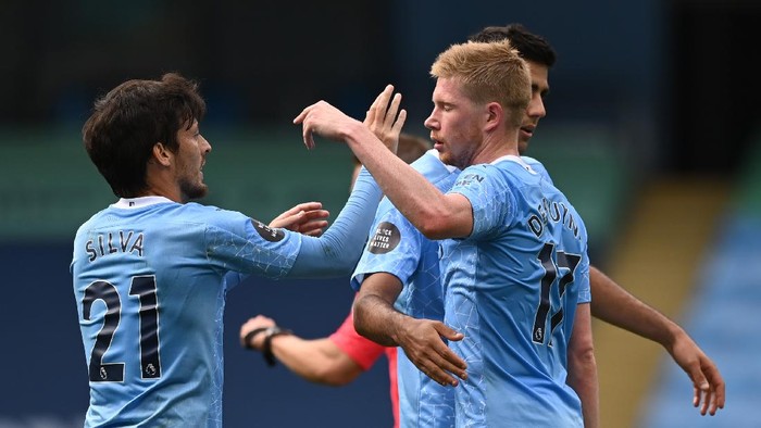 MANCHESTER, ENGLAND - JULY 26: Kevin De Bruyne of Manchester City and teammate David Silva celebrate after scoring his sides second goal during the Premier League match between Manchester City and Norwich City at Etihad Stadium on July 26, 2020 in Manchester, England.Football Stadiums around Europe remain empty due to the Coronavirus Pandemic as Government social distancing laws prohibit fans inside venues resulting in all fixtures being played behind closed doors. (Photo by Shaun Botterill/Getty Images)