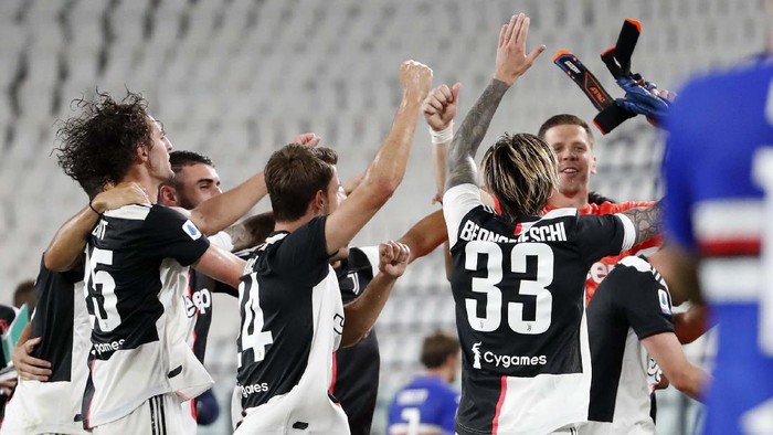Juventus players celebrate at the end of Serie A soccer match between Juventus and Sampdoria at the Allianz stadium, in Turin, Italy, Sunday, July 26, 2020. Juventus clinched a record-extending ninth successive Serie A title after it defeated Sampdoria 2-0. (AP Photo/Antonio Calanni)