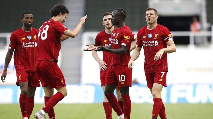 Liverpools Sadio Mane, center, celebrates with teammates after scoring his sides third goal during the English Premier League soccer match between Newcastle and Liverpool at St. James Park in Newcastle, England, Sunday, July 26, 2020. (Owen Humphreys, Pool via AP)