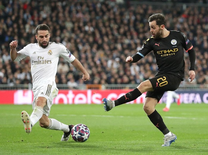 MADRID, SPAIN - FEBRUARY 26: Bernardo Silva of Manchester City shoots as Daniel Carvajal of Real Madrid attempts to block during the UEFA Champions League round of 16 first leg match between Real Madrid and Manchester City at Bernabeu on February 26, 2020 in Madrid, Spain. (Photo by Gonzalo Arroyo Moreno/Getty Images)