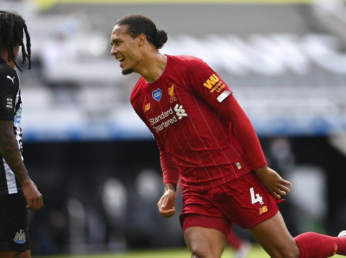 Liverpool's Virgil van Dijk celebrates after scoring his side's first goal during the English Premier League soccer match between Newcastle and Liverpool at St. James' Park in Newcastle, England, Sunday, July 26, 2020. (Laurence Griffiths, Pool via AP)
