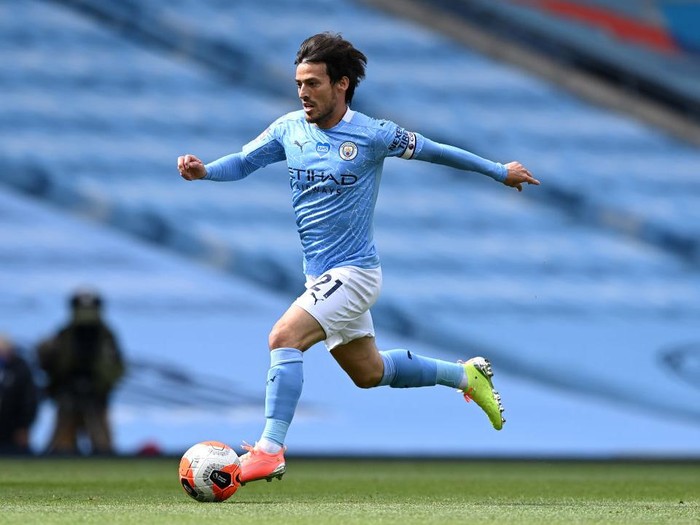 MANCHESTER, ENGLAND - JULY 26:  David Silva of Manchester City runs with the ball during the Premier League match between Manchester City and Norwich City at Etihad Stadium on July 26, 2020 in Manchester, England. Football Stadiums around Europe remain empty due to the Coronavirus Pandemic as Government social distancing laws prohibit fans inside venues resulting in all fixtures being played behind closed doors. (Photo by Shaun Botterill/Getty Images)