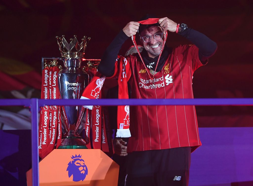 LIVERPOOL, ENGLAND - JULY 22: Jurgen Klopp, Manger of Liverpool puts on his winners medal during the presentation ceremony of the Premier League match between Liverpool FC and Chelsea FC at Anfield on July 22, 2020 in Liverpool, England. Football Stadiums around Europe remain empty due to the Coronavirus Pandemic as Government social distancing laws prohibit fans inside venues resulting in games being played behind closed doors. (Photo by Laurence Griffiths/Getty Images)