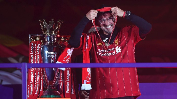 LIVERPOOL, ENGLAND - JULY 22: Jurgen Klopp, Manger of Liverpool puts on his winners medal during the presentation ceremony of  the Premier League match between Liverpool FC and Chelsea FC at Anfield on July 22, 2020 in Liverpool, England. Football Stadiums around Europe remain empty due to the Coronavirus Pandemic as Government social distancing laws prohibit fans inside venues resulting in games being played behind closed doors. (Photo by Laurence Griffiths/Getty Images)
