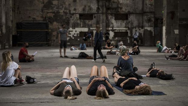 Visitors listen to the sound installation ìeleven songs ñ halle am berghainî at Berghain club in Berlin on July 24, 2020. - The sound installation of Sam Auinger and Hannes Strobl called tamtam was conceived especially for the hall and uses acoustic means to activate the architecture of the spatial arrangement, while the dance club itself remain closed due to the novel coronavirus COVID-19 pandemic. (Photo by STEFANIE LOOS / AFP)