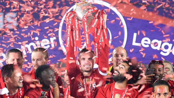 LIVERPOOL, ENGLAND - JULY 22: Jordan Henderson of Liverpool holds the Premier League Trophy aloft along side Mohamed Salah as they celebrate winning the League during the presentation ceremony of the Premier League match between Liverpool FC and Chelsea FC at Anfield on July 22, 2020 in Liverpool, England. Football Stadiums around Europe remain empty due to the Coronavirus Pandemic as Government social distancing laws prohibit fans inside venues resulting in games being played behind closed doors. (Photo by Laurence Griffiths/Getty Images)